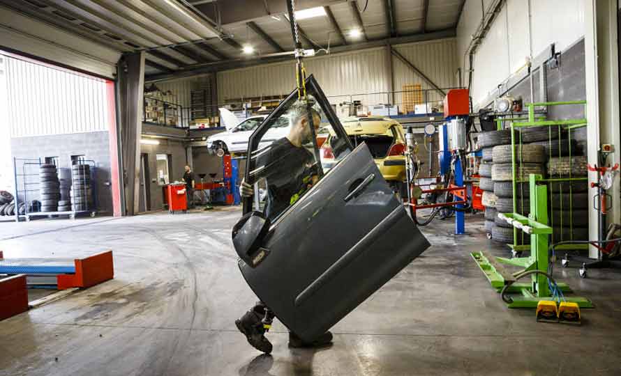 Un employé de Surplus Autos, à Gaillac, emporte une portière qu’il vient de démonter sur un véhicule accidenté.