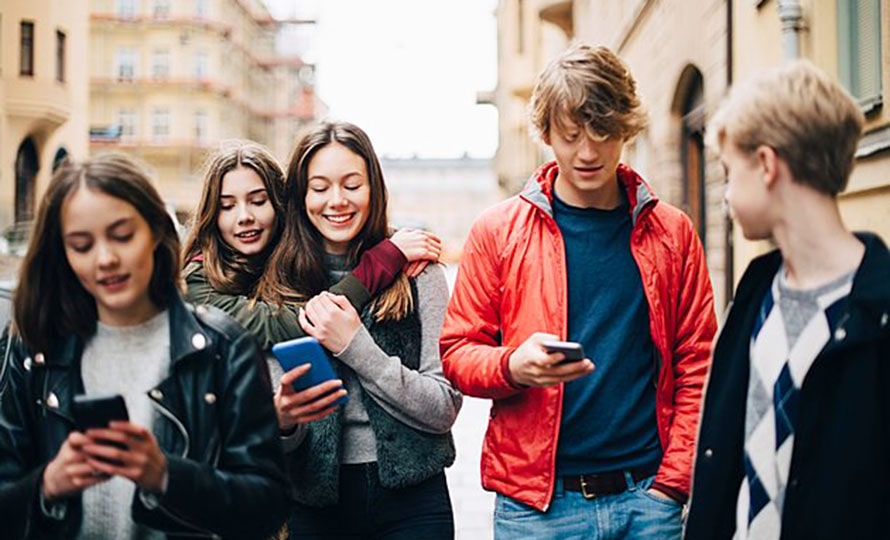 Jeunes dans la rue avec leur téléphone portable