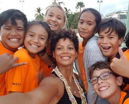 Coralie Balmy entourée des enfants auxquels elle apprend à nager et à protéger la mer.