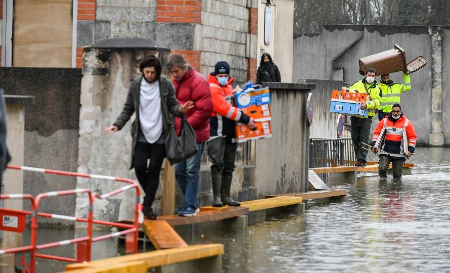 Des habitants évacuent un quartier inondé avec l'aide des secours