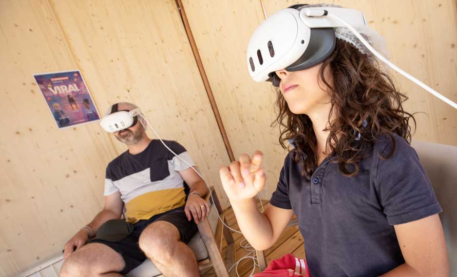 Un père et son fils, équipés d'un casque de réalité virtuelle, testent une animation 3D