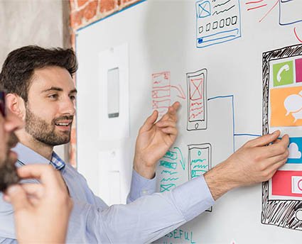 Un homme travaille sur un tableau blanc